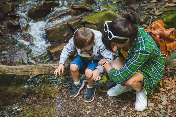 Mère avec enfant près de montagne rivière — Photo