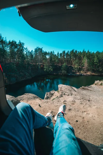 Człowiek siedzi w bagażniku samochodu patrząc na jezioro. piękny widok krajobrazu — Zdjęcie stockowe