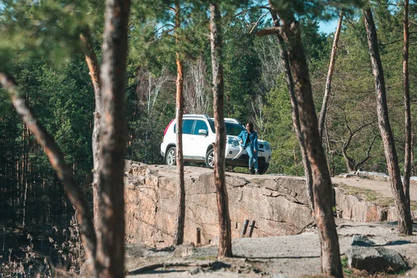 Coche suv blanco en el acantilado rocoso joven mujer cerca de ella — Foto de Stock