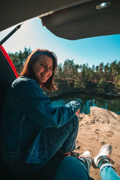 Pareja en el maletero del coche con hermosa vista del lago. vista en primera persona. joven sonriente mujer — Foto de Stock