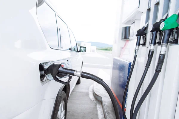 Jong mooi vrouw bij tankstation tanken tot auto tank — Stockfoto