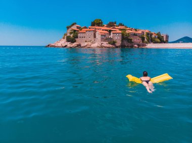 genç güzel kadın mavi denizde yüzme. Sveti stefan plaj