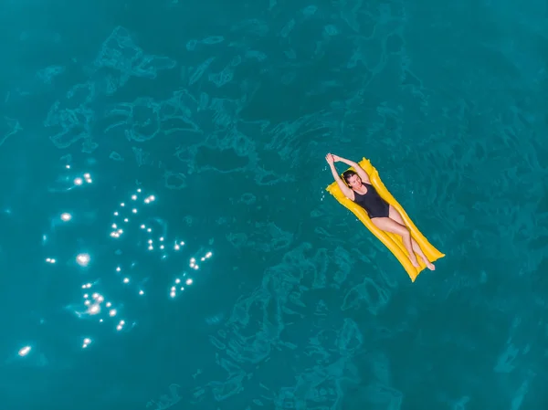 Jonge vrouw zwemmen in blauw azuurblauw water — Stockfoto