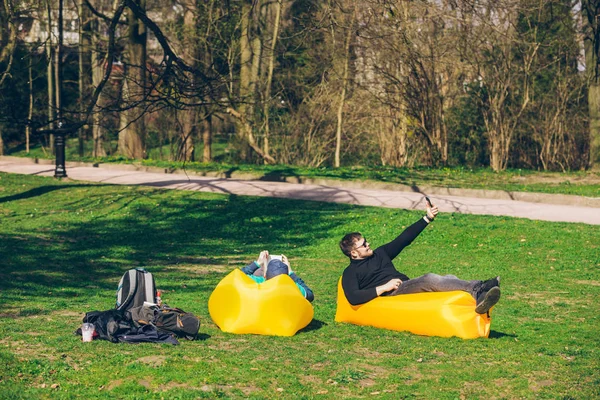 두 남자 친구 누워 에 누워 노란색 팽창식 매트리스 독서 책 서핑 인터넷 — 스톡 사진