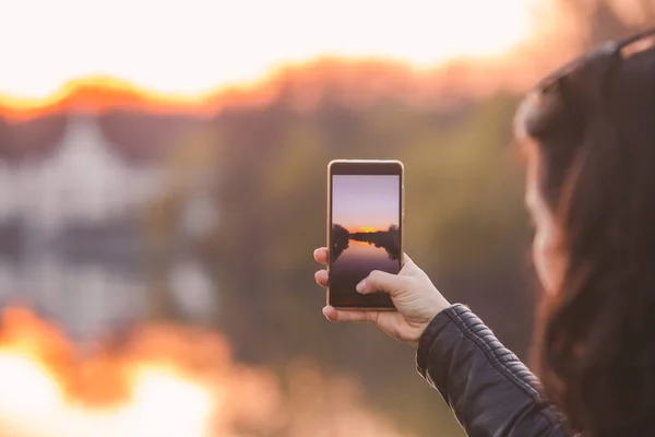 携帯電話で日没の写真を撮る女性は — ストック写真