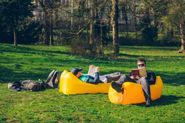 iki erkek arkadaş sarı şişme yatak kitap okuma yumurtlama