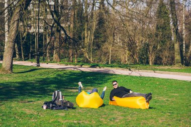 iki erkek arkadaşlar internet sörf kitapları okuma sarı şişme yatak üzerinde döşeme