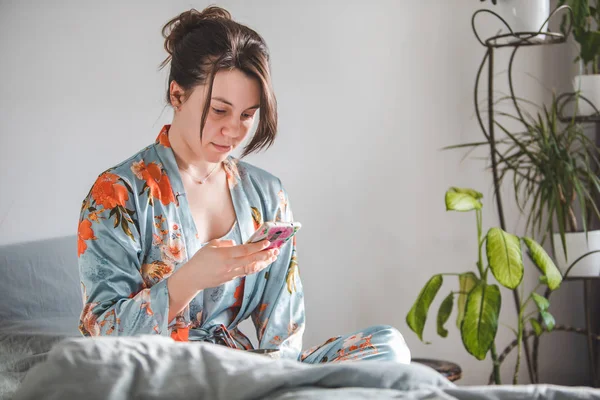 Frauenmorgen. im Bett mit Telefon. — Stockfoto