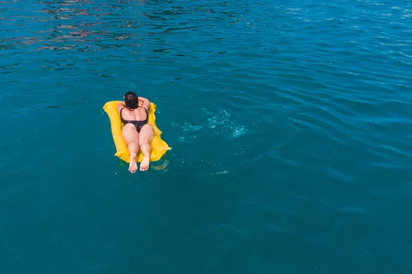 Jeune femme nageant dans l'eau bleue azur — Photo