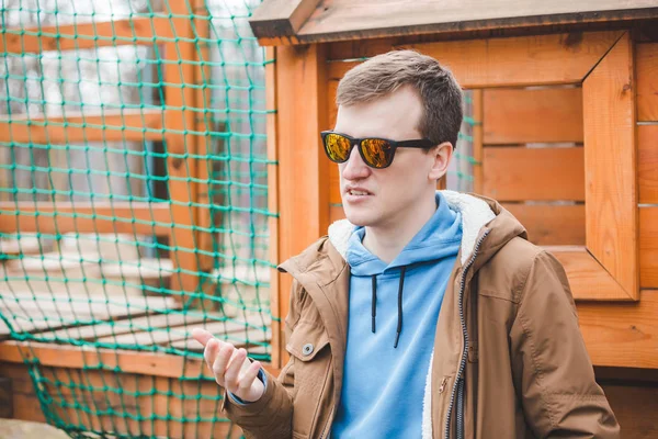 Молодой говорящий взрослый мужчина в солнцезащитных очках — стоковое фото