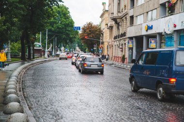 Lviv, Ukrayna - 14 Haziran 2018: Eski Avrupa şehrinde yağmurlu havalarda araç trafiği