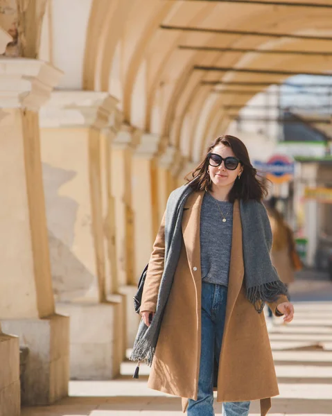 Jovem mulher muito na moda andando de casaco marrom por rua — Fotografia de Stock