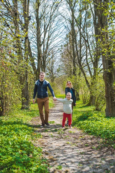 화창한 날에 공원 산책로로 걷는 3 명의 가족 — 스톡 사진