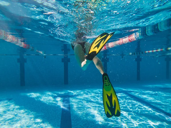 Nő a sárga békaláb úszás a medencében — Stock Fotó