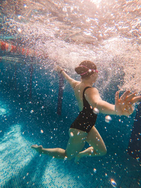 A medencében úszó nő. erős fény — Stock Fotó