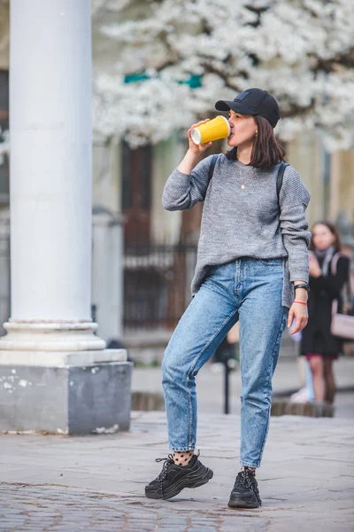 Mujer joven y elegante caminando por la calle con taza de café —  Fotos de Stock