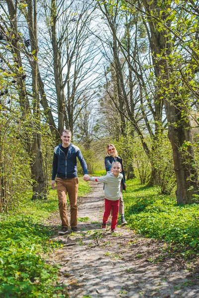 Family of three walking by park trail in sunny day — Stock Photo, Image