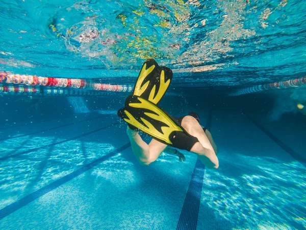 Kobieta w żółte płetwy pływanie w basenie — Zdjęcie stockowe