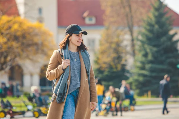 Jovem mulher muito na moda andando de casaco marrom por rua — Fotografia de Stock