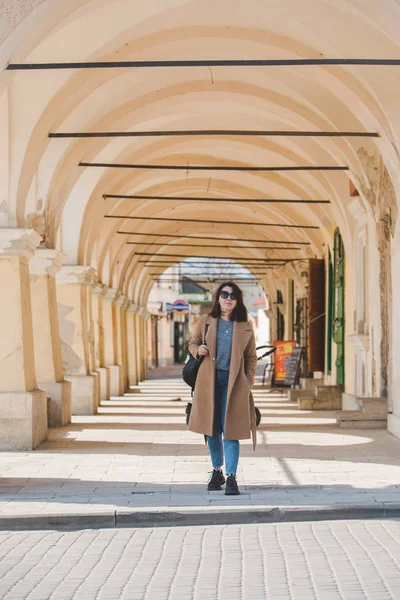 Jovem mulher muito na moda andando de casaco marrom por rua — Fotografia de Stock