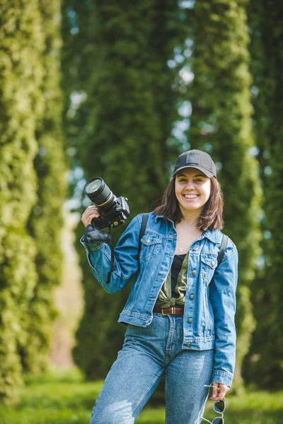 Mulher bonita fotógrafo segurando câmera profissional — Fotografia de Stock