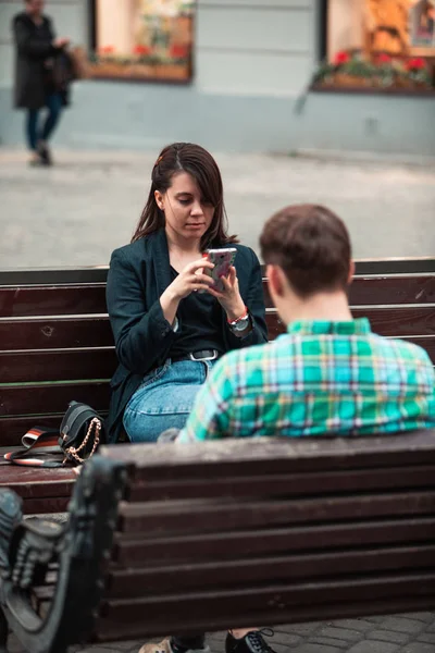 Comunicação problema homem com mulher sentado no banco na rua da cidade beber café em copo de papel olhando para telefones ito — Fotografia de Stock