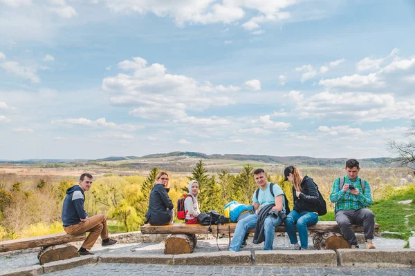 Grupo de amigos con niños sentados en un banco de madera con hermosa vista — Foto de Stock