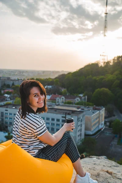 Frau trinkt Kaffee mit schönem Blick auf den Sonnenuntergang über der Stadt Lwiw in der Ukraine — Stockfoto