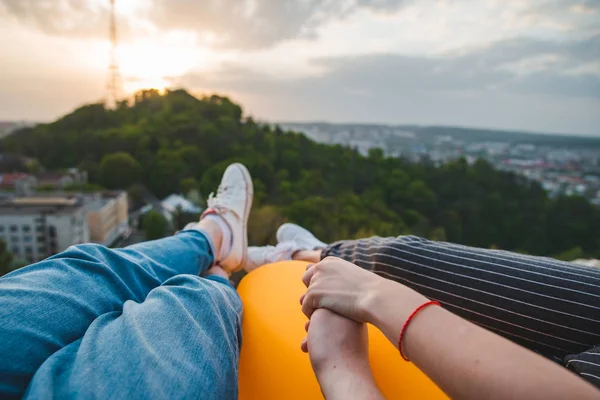 Casal deitado e desfrutando de vista do pôr do sol sobre a cidade — Fotografia de Stock