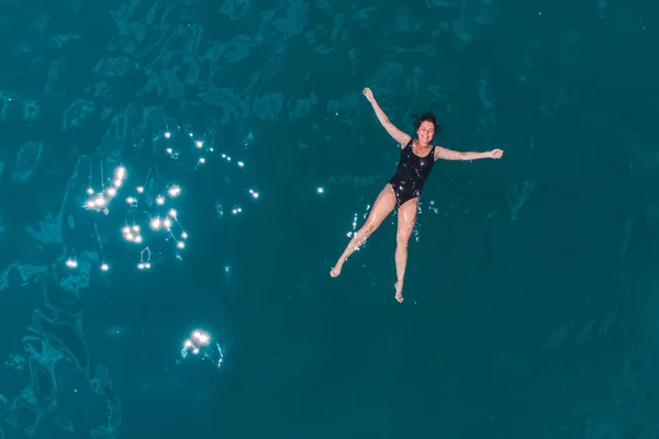 Junge Frau schwimmt im blauen azurblauen Wasser — Stockfoto