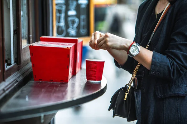 Woman put sugar in red paper coffee cup — Stock Photo, Image