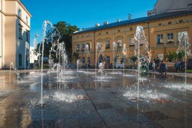 çeşme yakınındaki şehir meydanında oynayan çocuklar