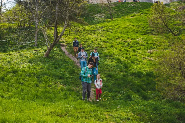 Feliz grupo de adultos con niños caminando por el parque cerca del viejo castillo — Foto de Stock