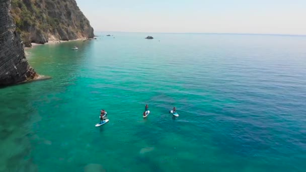 Sörf Tahtasındaki Kürekli Insanlar Kayalık Sahil Yaz Saati Kavramı — Stok video