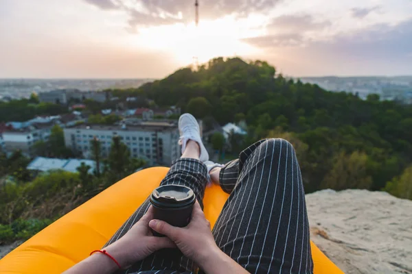 Mujer mirando el atardecer sobre la ciudad. beber café — Foto de Stock