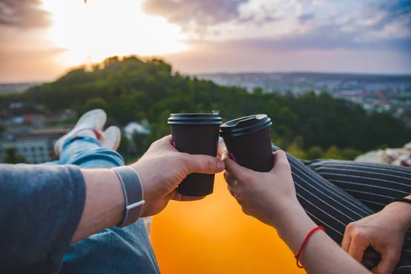 Paar leggen en genieten van uitzicht op de zonsondergang over de stad. koffie drinken — Stockfoto