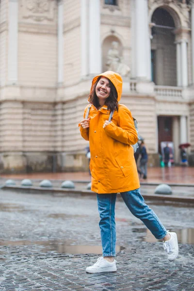 Mladá krásná usměvavá ženská portrét v pláštěnec s kapucí — Stock fotografie