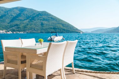 güzel bir deniz ve dağ manzarası ile sahilde Cafe tablo