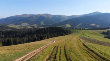 arka planda vadi izi dağlar tarafından hareket eden beyaz suv araba üst görünümü. akşam saati