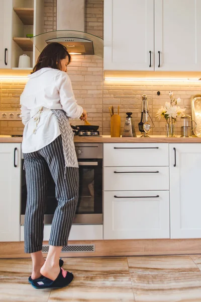 Vista desde detrás de la mujer en la cocina cocina — Foto de Stock