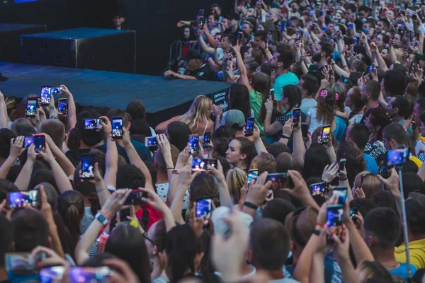 LVIV, UCRANIA - 18 de junio de 2019: cantante de banda de rock en el escenario con multitud de micrófonos alrededor del escenario grabando en teléfonos —  Fotos de Stock