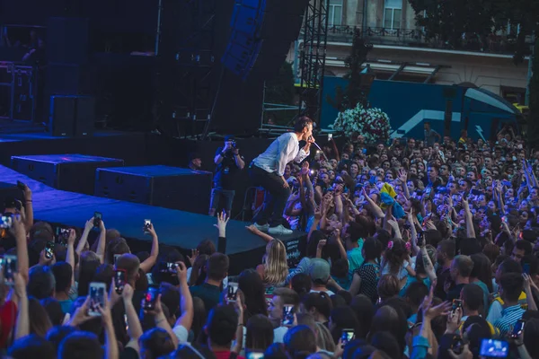 Lviv, ukraine - 18. Juni 2019: Sänger der Rockband auf der Bühne mit Mikrofon-Publikum rund um die Bühne, das auf Telefone schießt — Stockfoto