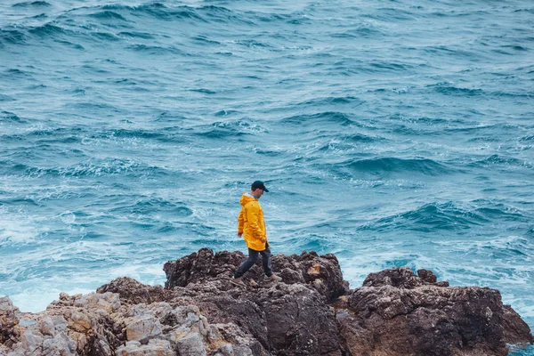 Homem andando por rocha para invadir o mar — Fotografia de Stock