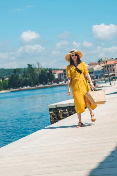 Kvinna som går vid havet kaj i sommardag i Yellow sundress — Stockfoto