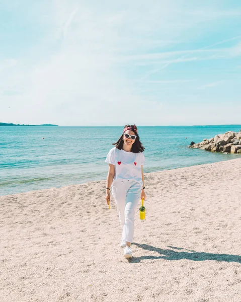 Kvinna i vita kläder Walking by Sea Beach i soliga dagar — Stockfoto