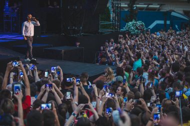 Lviv, Ukrayna - 18 Haziran 2019: rock grubu şarkıcısı sahnede mikrofon kalabalığıyla sahnede telefonlarda çekim