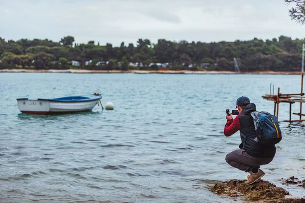 Homem tirando foto do barco em mar baía tempestuoso tempo — Fotografia de Stock