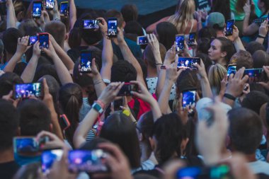 Lviv, Ukrayna - 18 Haziran 2019: rock grubu şarkıcısı sahnede mikrofon kalabalığıyla sahnede telefonlarda çekim