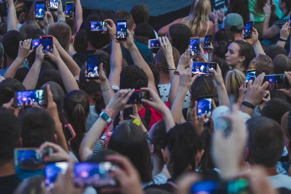 Lwów, Ukraina-18 czerwca 2019: piosenkarka rockowa na scenie z mikrofonem tłum wokół fotografowania sceny na telefony — Zdjęcie stockowe