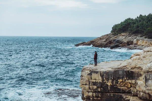 Homem de pé na borda olhando para o mar tempo ventoso — Fotografia de Stock